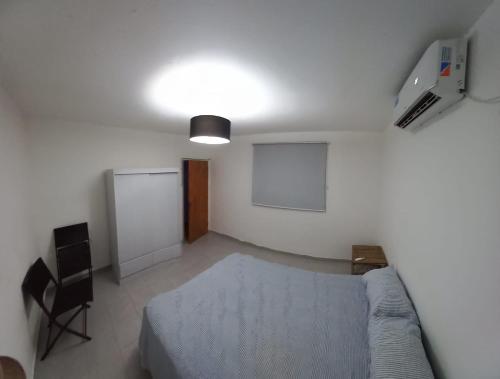 1 dormitorio con 1 cama y 1 silla en Samay kusy 2, en La Rioja