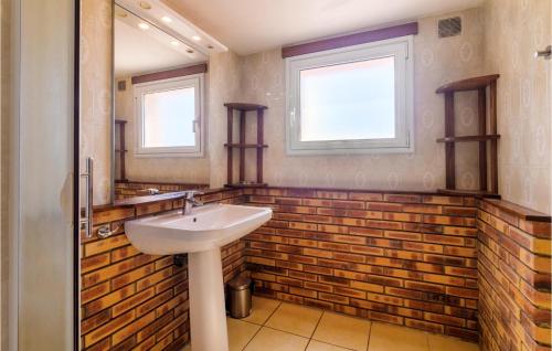アゲにあるDomaine De La Bastide Dagayのレンガの壁、洗面台付きのバスルーム