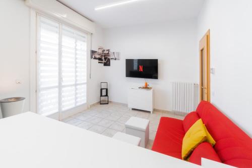 a living room with a red couch and a tv at Viale della Repubblica free parking e Wifi 1 minute to Garda Lake in Peschiera del Garda