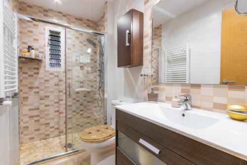 a bathroom with a toilet and a sink and a shower at Villa Joana in Palma de Mallorca