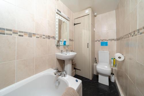 a bathroom with a tub and a sink and a toilet at Kingfisher Cottage at Robin Hill 4 in Bideford