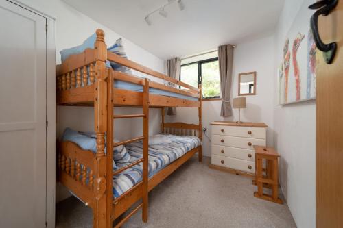 1 dormitorio con 2 literas y escritorio en Heron Cottage at Robin Hill 6 en Bideford