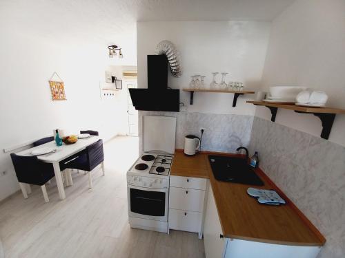 a kitchen with a stove and a counter top at Apartments Toni in Rogoznica