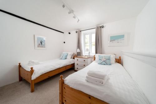 比迪福德的住宿－Wren Cottage at Robin Hill 4，一间卧室设有两张床和窗户。