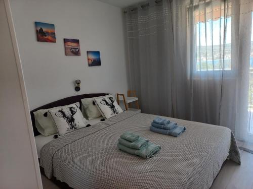 1 dormitorio con 1 cama con 2 toallas en Apartments Toni, en Rogoznica