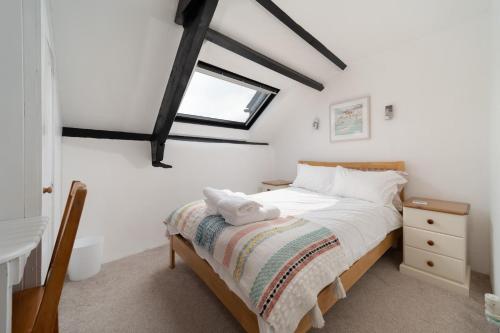 een slaapkamer met een bed en een raam bij Swallow Cottage at Robin Hill 4 in Bideford
