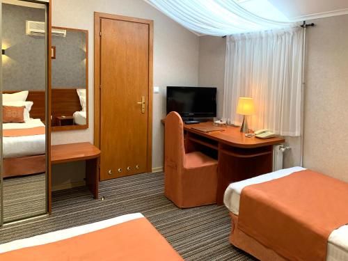 a hotel room with a desk and a bedroom at Economy room in Hotel Eney in Lviv