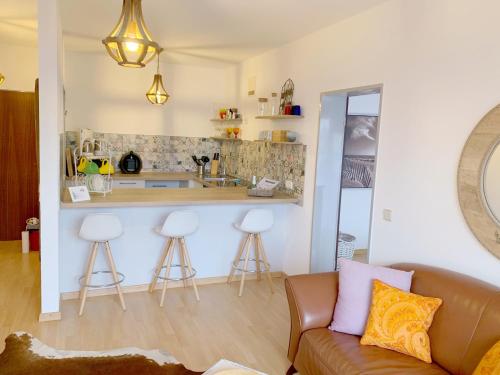 ein Wohnzimmer mit einem Sofa und einer Küche in der Unterkunft Deickrone App 10 inkl WLAN in Grömitz