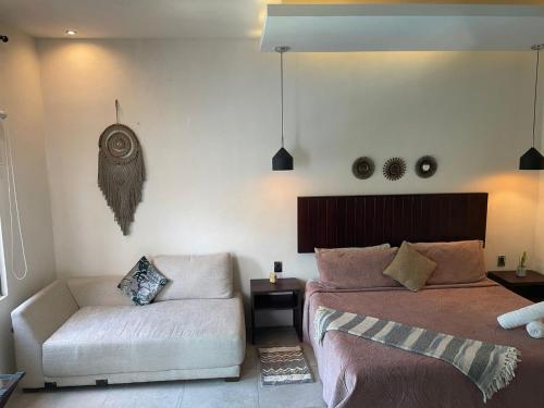 um quarto com uma cama e um sofá em Hotel Diosa del Agua Bacalar em Bacalar