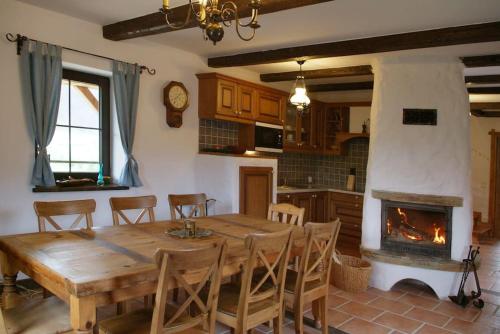 a dining room with a wooden table and a fireplace at Chata Sanna in Lesko