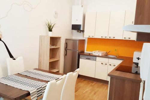 a kitchen with white cabinets and a table and a refrigerator at Relax Apartment Vienna City Center in Vienna