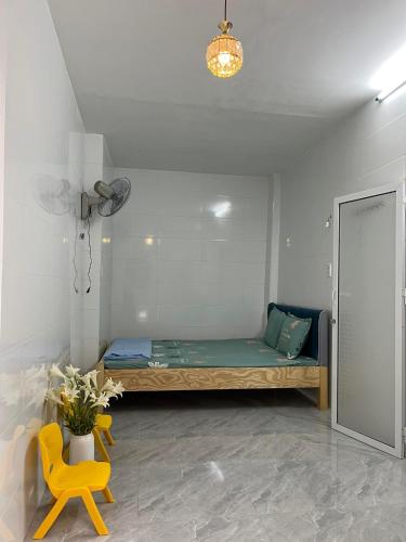 Zimmer mit einem Bett und einem gelben Stuhl in der Unterkunft Homestay Hoa Anh in Haiphong