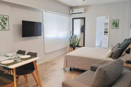 a bedroom with a bed and a table and a couch at Via Buenos Aires- Studio Microcentro in Buenos Aires