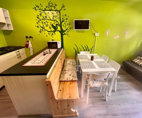 eine Küche mit einem Tisch und einem Baum an der Wand in der Unterkunft Il Nido Dell'Aquila-Piancavallo in Piancavallo
