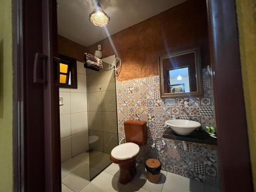 a bathroom with a shower and a toilet and a sink at Pousada Recanto dos Leões in Pirenópolis
