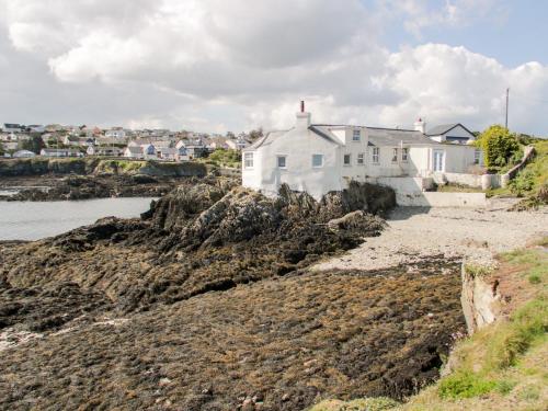 a white house on the shore of a body of water at Craig Y Wylan in Amlwch