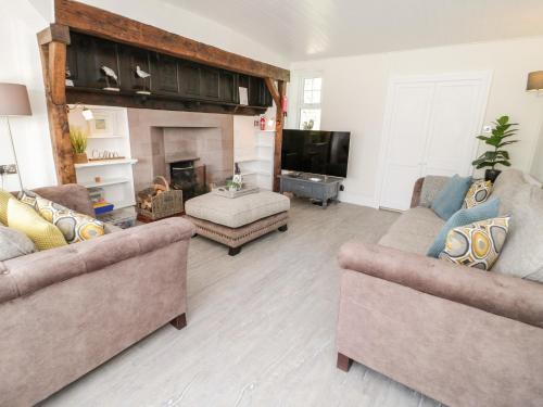 a living room with two couches and a fireplace at Craig Y Wylan in Amlwch