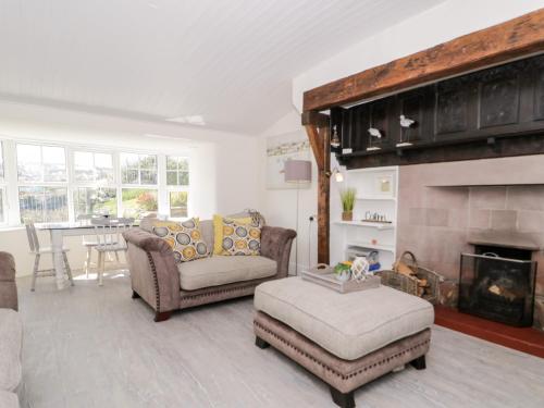 a living room with two couches and a fireplace at Craig Y Wylan in Amlwch