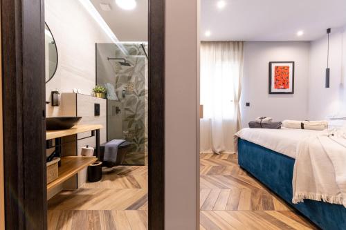 a bedroom with a bed and a sink and a mirror at West Coast Deluxe Rooms - Vacation Rental in Split