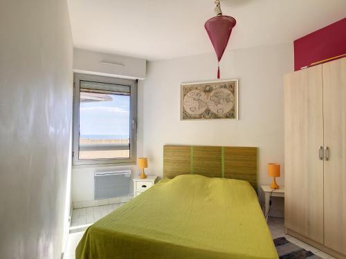 une chambre avec un lit vert et une fenêtre dans l'établissement Location saisonnière - F3 - 8 pers - 1ère ligne - Garage - Animaux acceptés - FR-1-715-3, à Mauguio