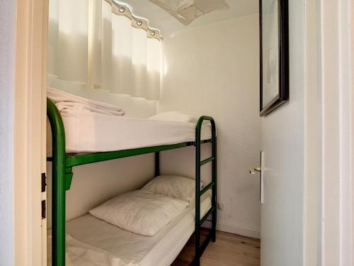 Ce lit superposé vert se trouve dans un dortoir doté d'un miroir. dans l'établissement Studio cabine moderne avec garage pour 4 personnes, vue mer - FR-1-715-15, à Mauguio