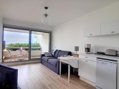 une cuisine et un salon avec un canapé et une table dans l'établissement Studio rénové sur plage avec cabine, parking et WIFI - FR-1-715-17, à Mauguio