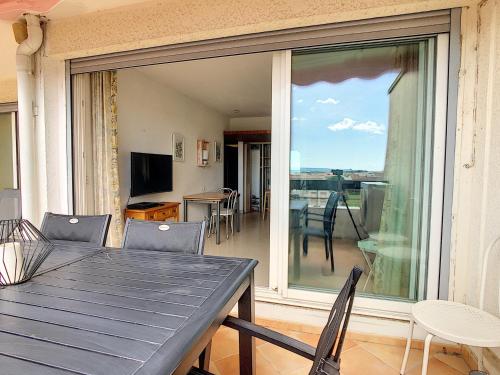 d'une salle à manger avec une table et une porte coulissante en verre. dans l'établissement Appartement T2 avec Terrasse, Climatisation et Parking - FR-1-715-22, à Mauguio