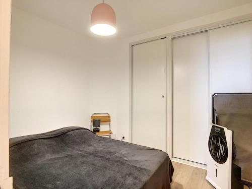 - une chambre avec un lit et des armoires blanches dans l'établissement Studio rénové sur plage avec cabine, parking et WIFI - FR-1-715-17, à Mauguio