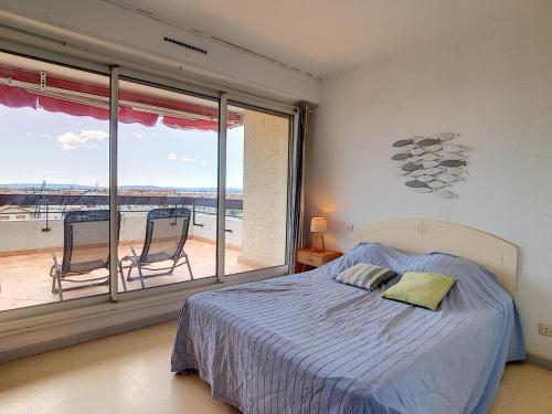 une chambre avec un lit et une grande fenêtre dans l'établissement Appartement T2 avec Terrasse, Climatisation et Parking - FR-1-715-22, à Mauguio