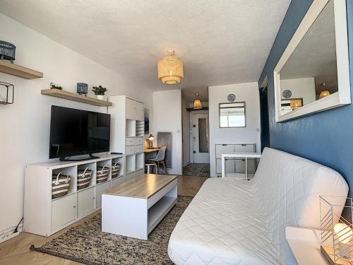 un salon avec un canapé blanc et une télévision dans l'établissement Studio Cabine Rénové Près Plage avec Parking Privé - FR-1-715-34, à Mauguio