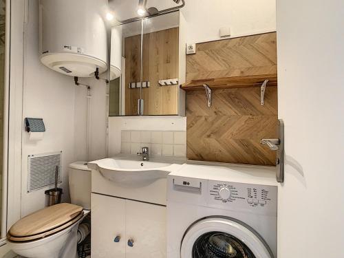 une petite salle de bains avec un lave-linge et un lavabo dans l'établissement Studio Cabine Rénové Près Plage avec Parking Privé - FR-1-715-34, à Mauguio