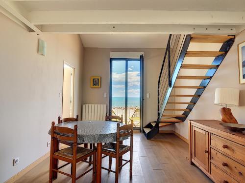 une salle à manger avec une table et une vue sur l'océan dans l'établissement Appartement mezzanine sur plage, rénové, wifi inclus - FR-1-715-32, à Mauguio