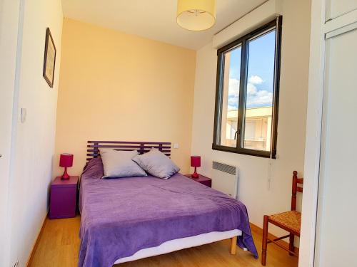 - une chambre avec un lit doté de draps violets et une fenêtre dans l'établissement Appartement mezzanine sur plage, rénové, wifi inclus - FR-1-715-32, à Mauguio