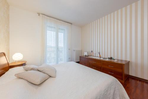 um quarto com uma cama, uma cómoda e uma janela em GIOTTO Guesthouse em Due Carrare