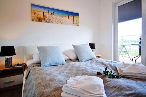 1 dormitorio con 1 cama con 2 toallas en Polanki Park E202, en Kołobrzeg