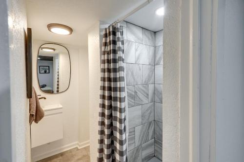 a bathroom with a shower curtain and a mirror at Pet-Friendly Wichita Home with Deck, Near Dtwn in Wichita
