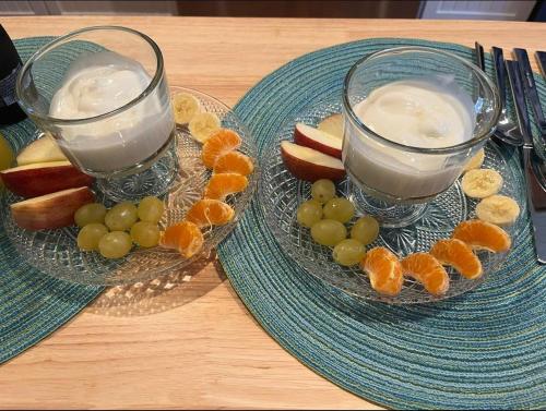 two plates of fruit and two glasses of milk at Baker Street Bed and Breakfast in Eufaula