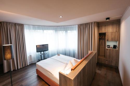a bedroom with a bed and a large window at City Park Hotel in Frankfurt Oder