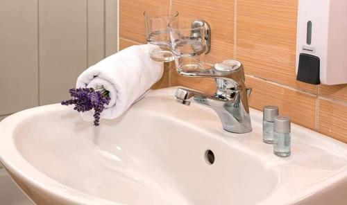 um lavatório de casa de banho com uma toalha e um vidro em Apartmani Lučica em Mimice
