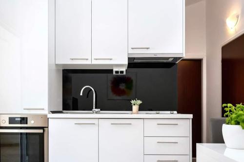 a kitchen with white cabinets and a sink at Apartmani Lučica in Mimice