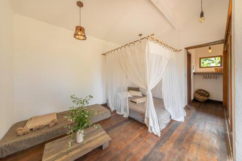 sypialnia z łóżkiem z moskitierą w obiekcie Casa do Jardim w mieście Serra Grande