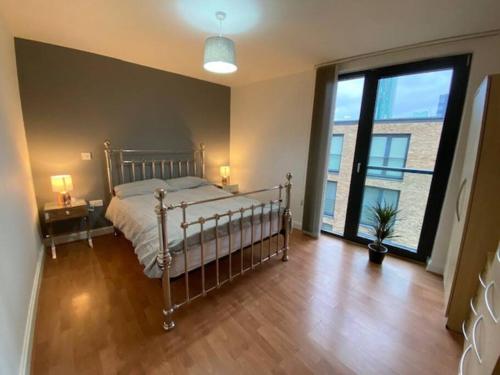 a bedroom with a bed and a large window at Superb 1 Bedroom Serviced Apartment In City Centre in Birmingham