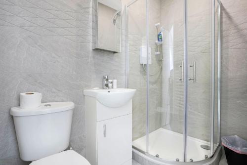 a white bathroom with a toilet and a shower at Central Buckingham Apartment #4 with Free Parking, Pool Table, Fast Wifi and Smart TV with Netflix by Yoko Property in Buckingham