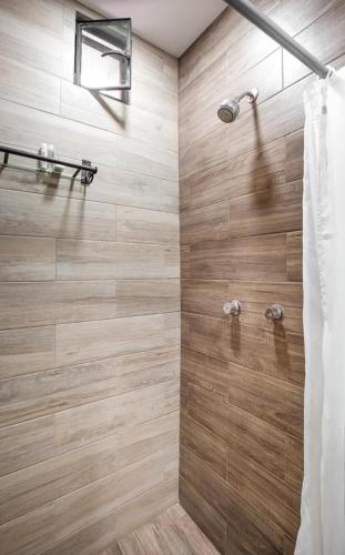 a bathroom with a shower with wooden tiles at Hotel El Andariego in Oaxaca City