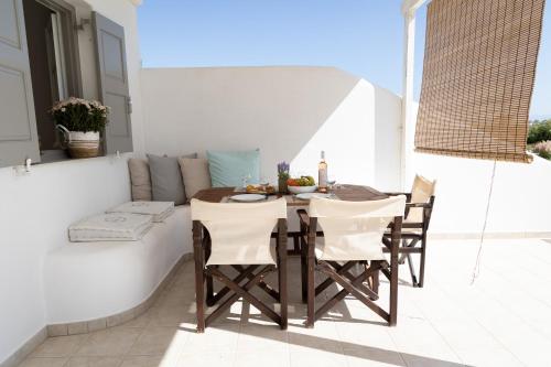 een patio met een tafel en stoelen op een balkon bij Seample studios in Chrissi Akti