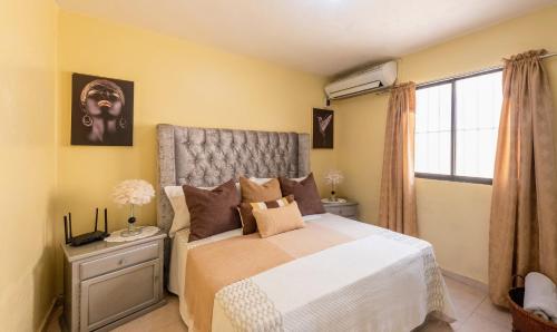 a bedroom with a large bed and a window at Acogedor Espacio en Santo Domingo Este. in Mandinga