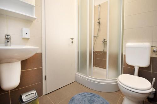 La salle de bains est pourvue de toilettes, d'un lavabo et d'une douche. dans l'établissement Apartments Sunspot 1, à Lokva Rogoznica