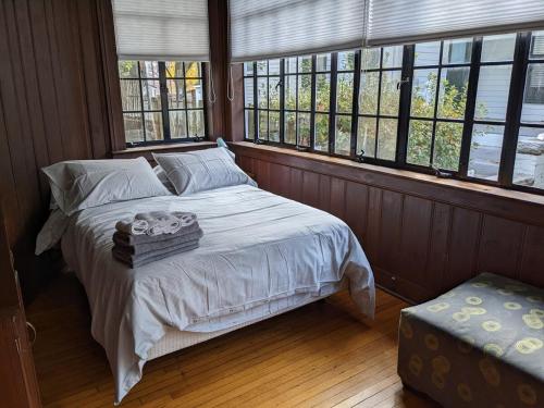 - une chambre avec un lit dans une pièce dotée de fenêtres dans l'établissement Spacious 3br Apt In Grand Old Home, Downtown Durham, à Durham