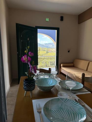 un tavolo con piatti e vista su una finestra di Assos BLUE house ad Ásos