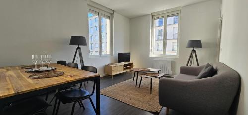 un salon avec une table et des chaises en bois dans l'établissement Bel appartement Clairmarais - Centre Reims - Gare, à Reims